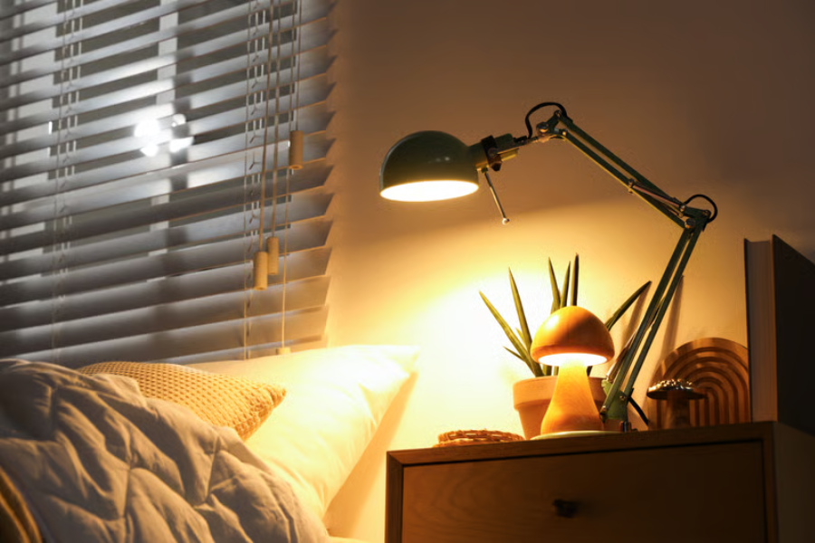 sudut kamar estetik dengan lampu meja dan dekorasi